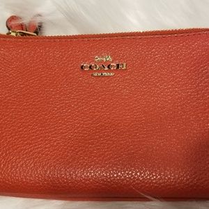 Orange leather Coach wristlet/wallet.
